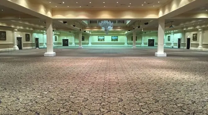 spacious banquet hall with ornate carpet, elegant chandeliers